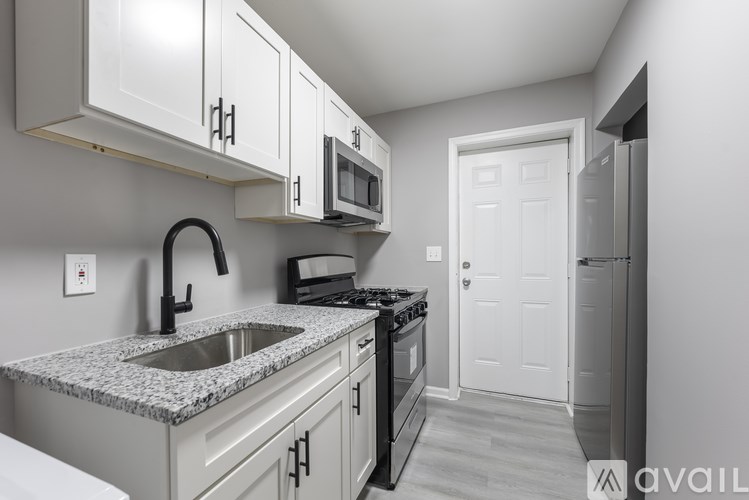 A kitchen with granite countertops and white cabinets.