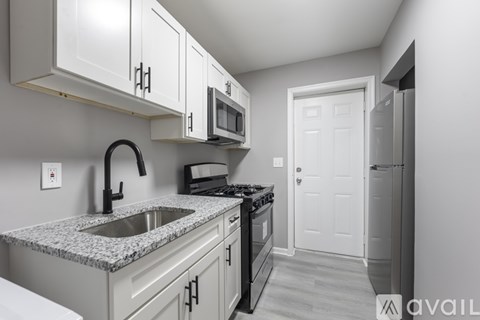 A kitchen with granite countertops and white cabinets.