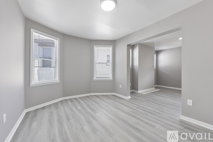 A room with a wooden floor and a window with blinds.