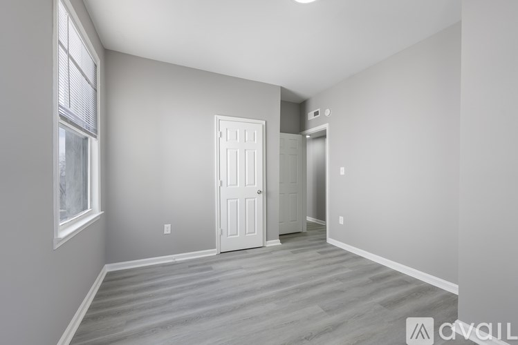 A room with a white door and a window with blinds.