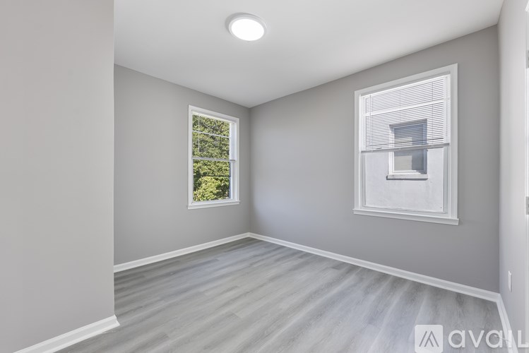 A room with a window and a wall-mounted light fixture.