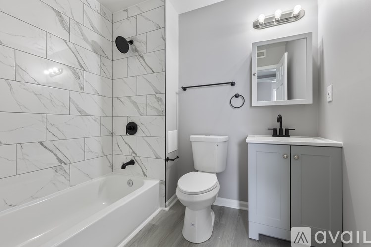 A bathroom with a white tub, toilet, and sink.