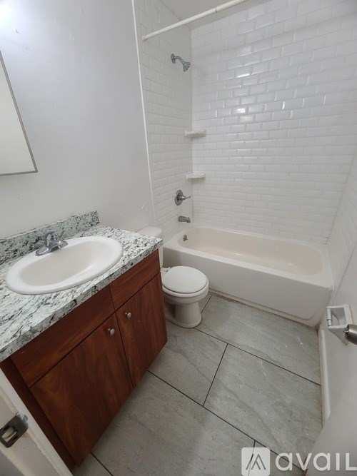 A bathroom with a white tub, sink, and toilet.