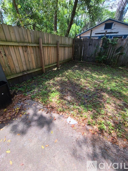 A backyard with a wooden fence and a shed.