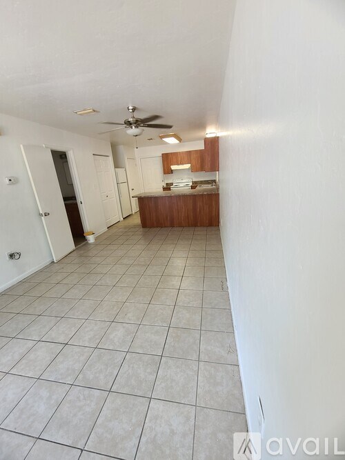 A room with a ceiling fan and tiled flooring.