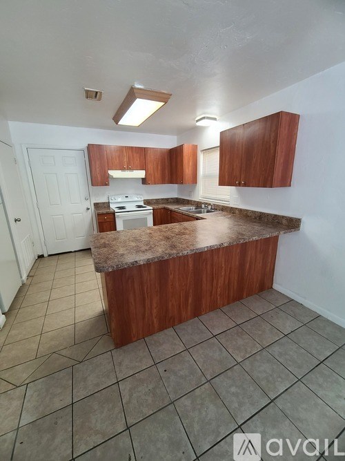 A kitchen with brown cabinets and a white door.