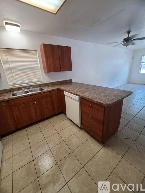 A kitchen with brown cabinets and a white dishwasher.