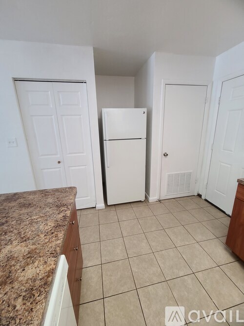 A kitchen with a granite countertop and white appliances.