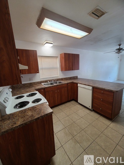 A kitchen with wooden cabinets and a white stove top oven.