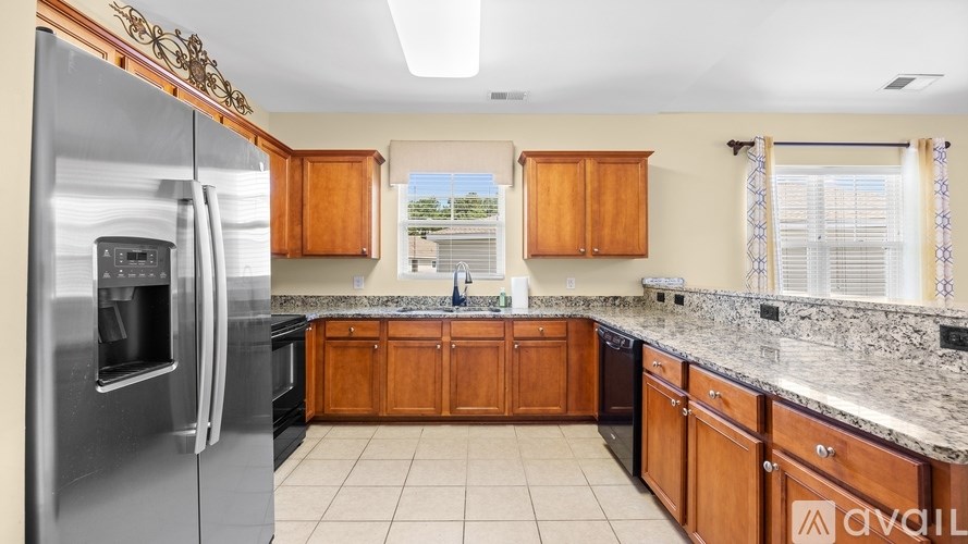 A kitchen with a refrigerator, cabinets, and a countertop.