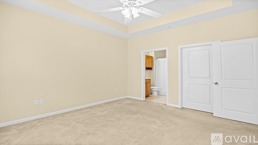 A room with a ceiling fan and two doors.