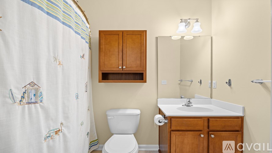 A bathroom with a toilet, sink, and shower curtain.