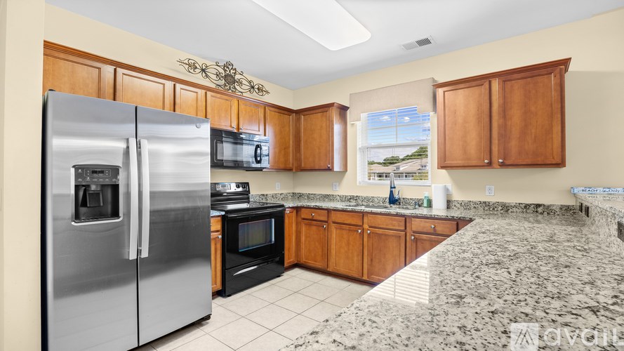 A kitchen with a granite counter top and stainless steel appliances.