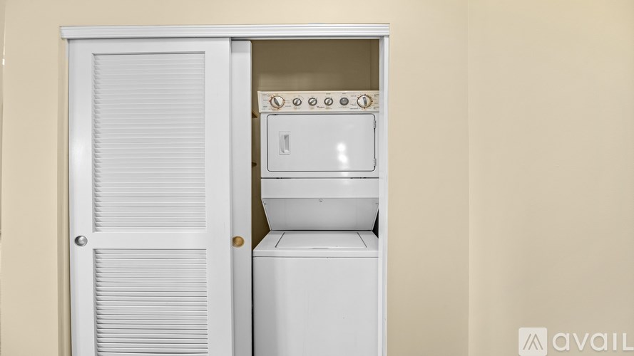 A white microwave oven is built into a cabinet.