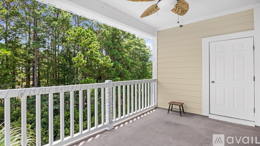 A balcony with a white railing and a ceiling fan.