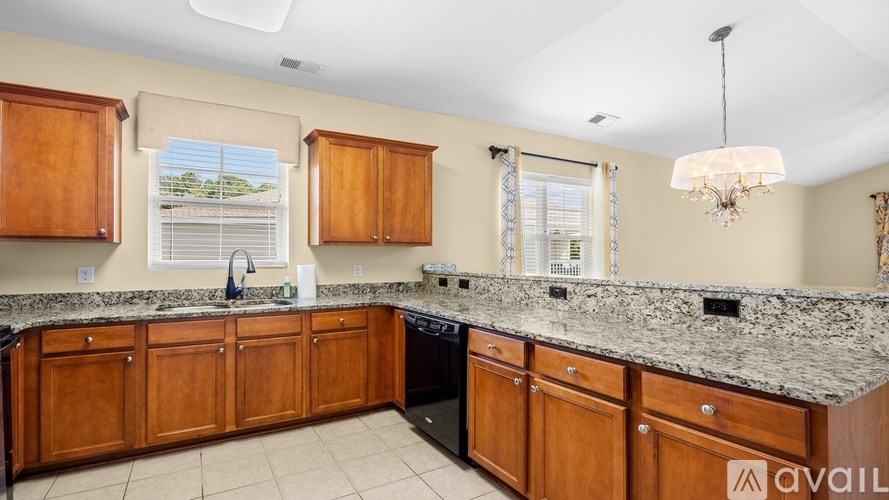 A kitchen with wooden cabinets and granite countertops.