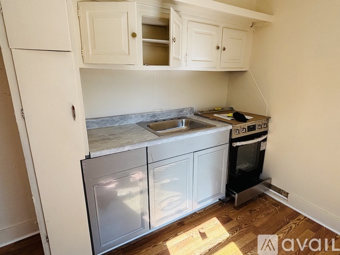 A kitchen with white cabinets and a stainless steel dishwasher.