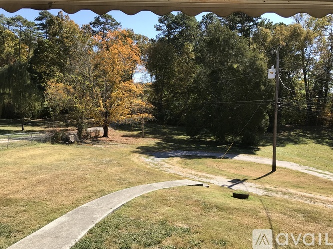 A grassy area with a path and trees in the background.