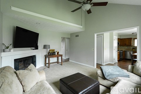 A living room with a fireplace and a television on the wall.