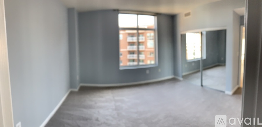 A large empty room with a window overlooking a building.
