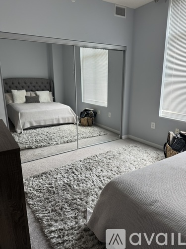 A bedroom with a large bed and a mirror on the wall.
