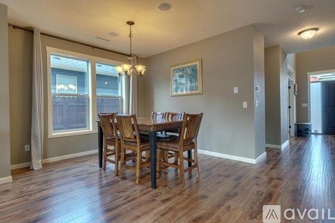 A dining room with a wooden table and chairs.