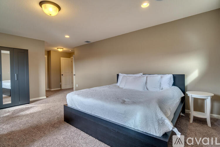 A bedroom with a large bed and a carpeted floor.