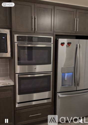 A modern kitchen with a stainless steel refrigerator and oven.
