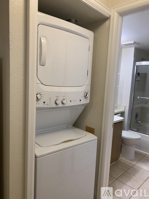 A white dryer and washer in a small bathroom.