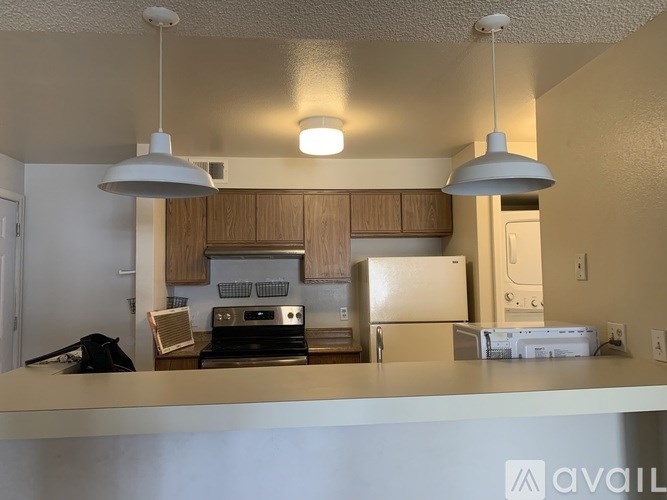 A kitchen with a white countertop and wooden cabinets.