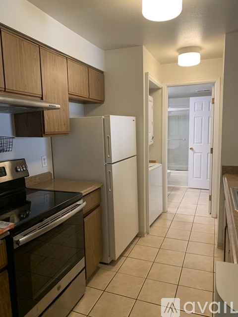 A kitchen with a white refrigerator and black stove top oven.