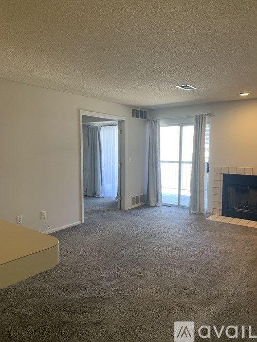 A living room with a fireplace and a sliding glass door.