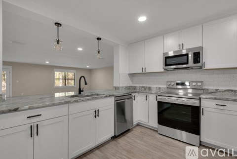 A kitchen with white cabinets and a granite countertop.