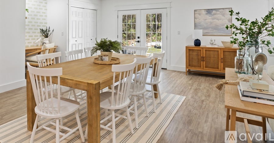 A dining room with a wooden table and chairs.