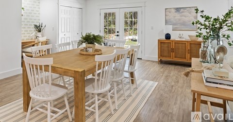 A dining room with a wooden table and chairs.
