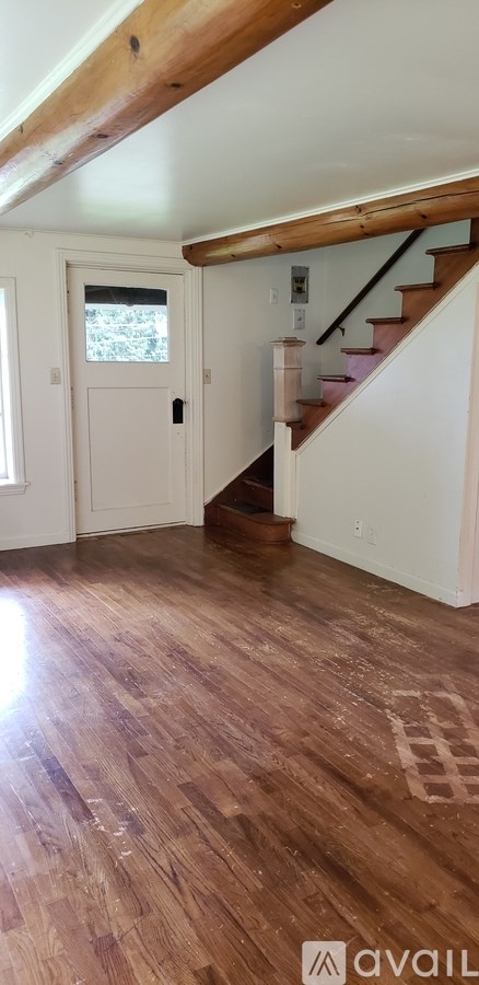 A room with wooden floors and a staircase.