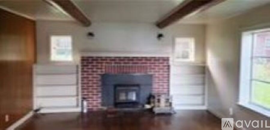 A living room with a fireplace and wooden floors.
