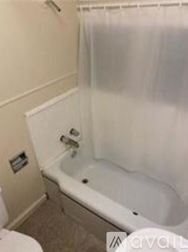 A white bathtub with a shower curtain in a bathroom.