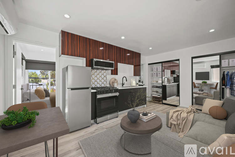 A modern kitchen with a refrigerator, oven, and a dining table with a potted plant on it.