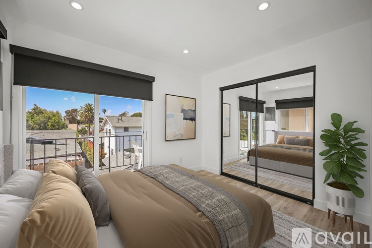 A bedroom with a large bed and a view of the outdoors through the window.
