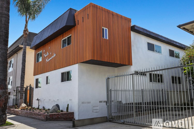 A modern building with a white and brown facade and a black roof.