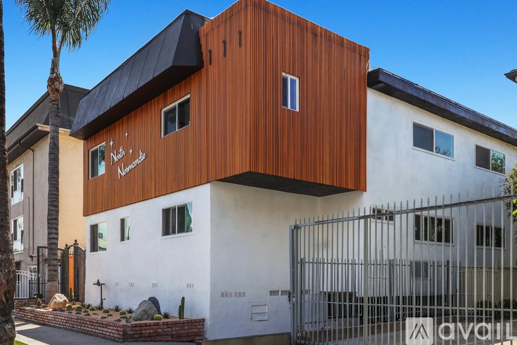 A modern house with a white and brown exterior and a black roof.