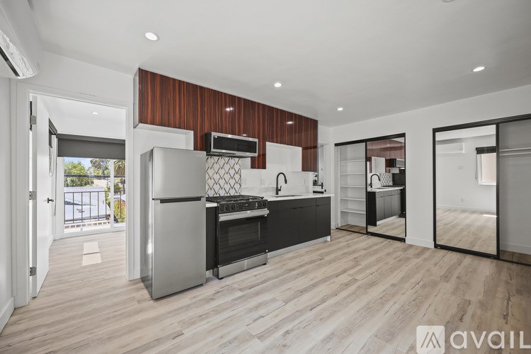 A modern kitchen with wooden cabinets and a stainless steel refrigerator.