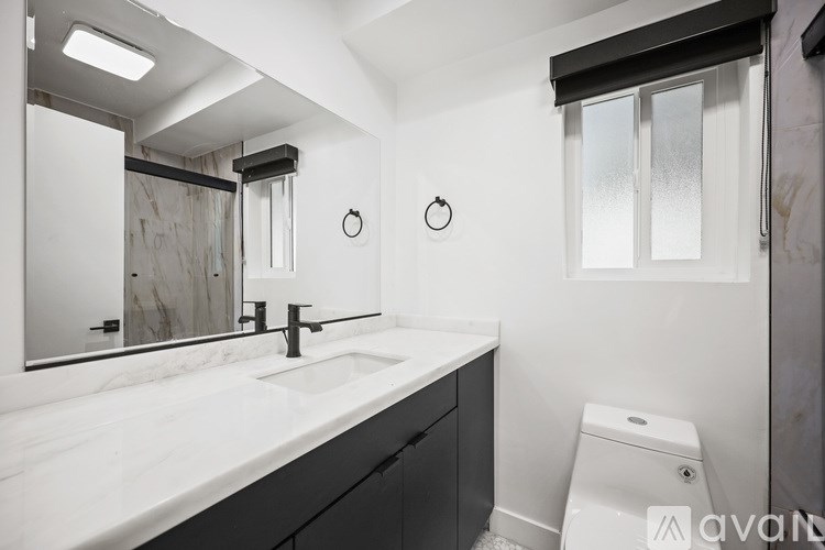 A bathroom with a sink, mirror, and toilet.