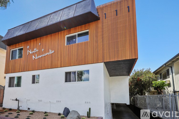 A modern building with a white and orange facade and the words "Nord + Nomandie" written on the top.