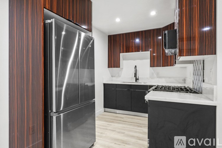 A modern kitchen with a stainless steel refrigerator and wooden cabinets.