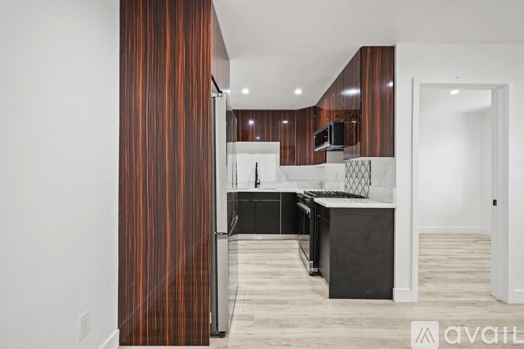 A modern kitchen with dark wood cabinets and a white countertop.