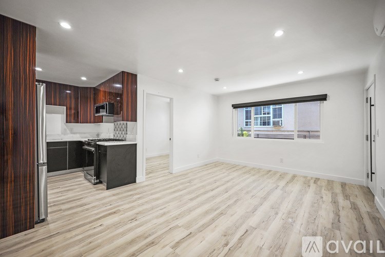 A spacious kitchen with wooden flooring and modern appliances.