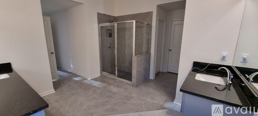 A bathroom with a sink, mirror, and shower.