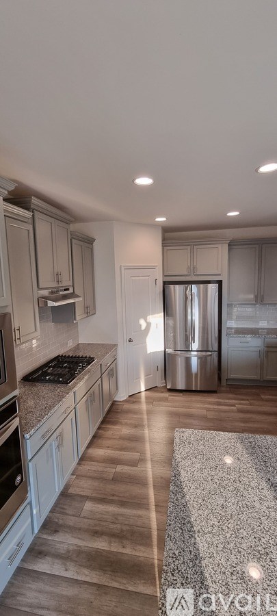 A kitchen with wooden floors and granite countertops.